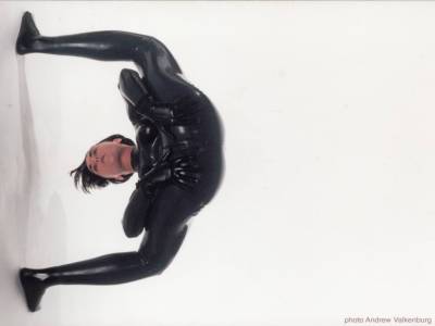 photo Contortion woman at work in shiny black skintight bodysuit